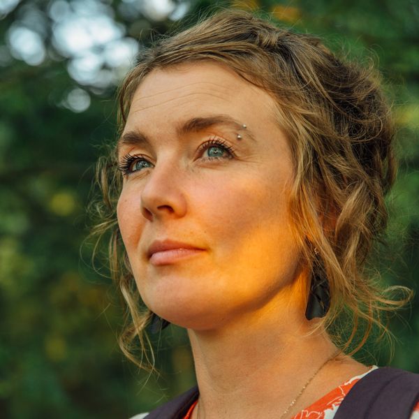 Author Reetta Ranta in a Finnish forest at golden hour